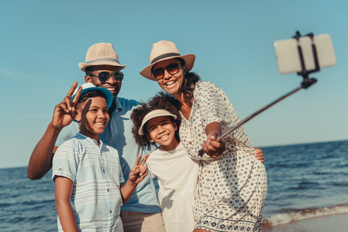 A family taking a selfie on the beach.