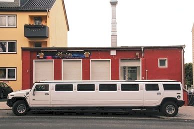 Picture of a stretched limo in front of a building.